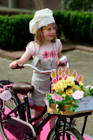 Young girl stands next to her flower decorated bicycle at the children's flower parade in Lisse, the Netherlands.